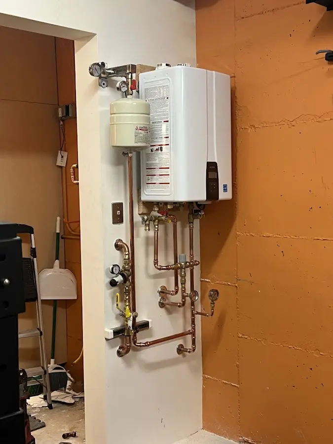 Plumbing technician inspecting water heater connections in Nelsonville